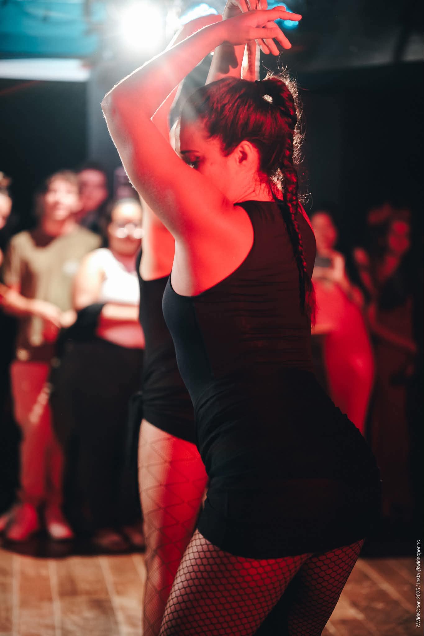 Manon Gerardin danse, les bras levés, sous des lumières de scène